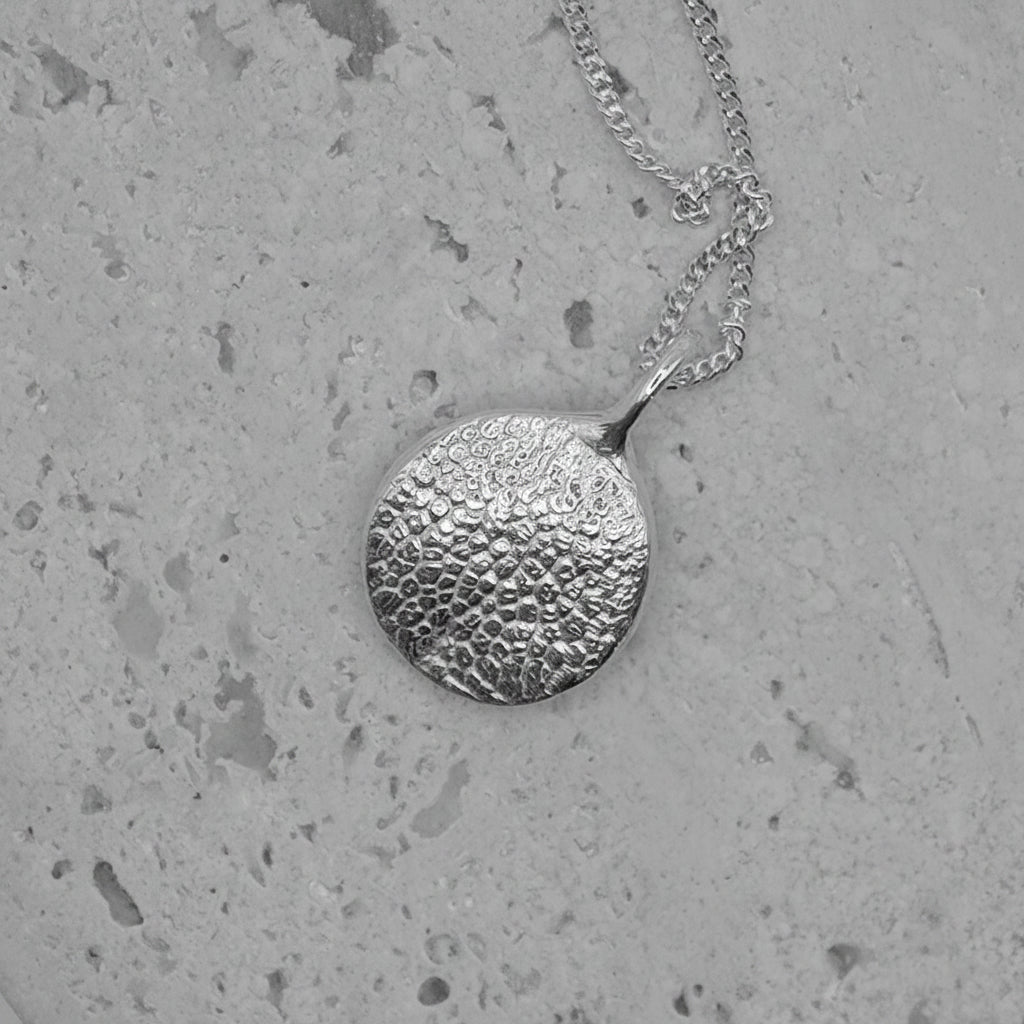 Médaillon en argent réalisé à partir du moulage de l'empreinte d'une truffe de chien. Réalisez votre pendentif truffe de chien sur mesure pour garder son souvenir pour toujours près de vous.