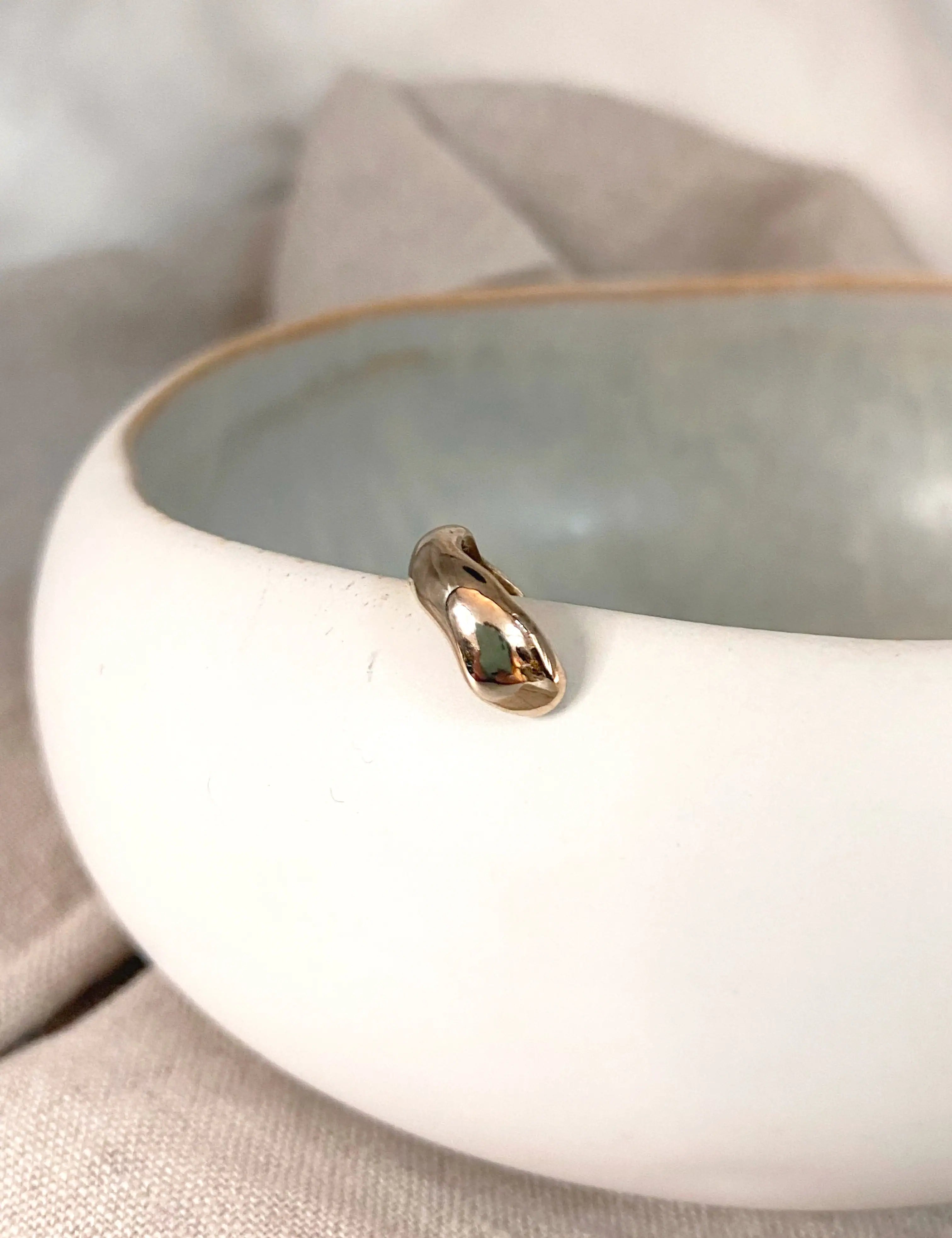 Bijou d’oreille fin et doré, earcuff asymétrique aux lignes fluides, façonné à la main en France.